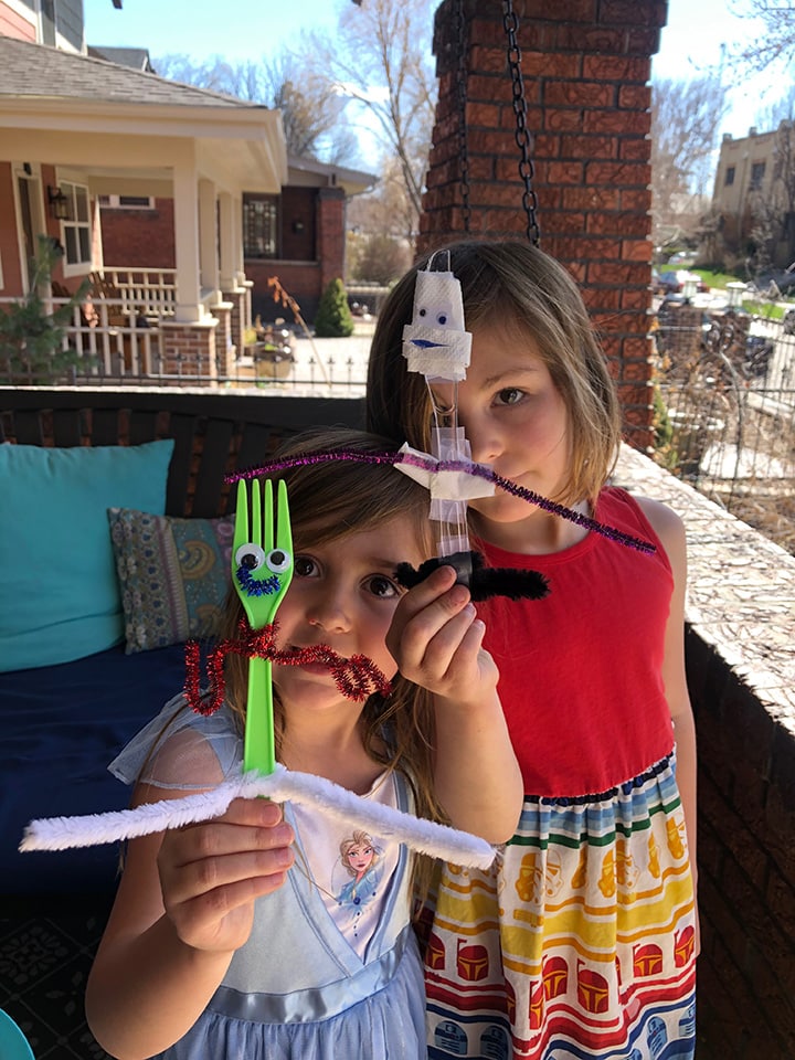 2 girls holding up their new crafts. 