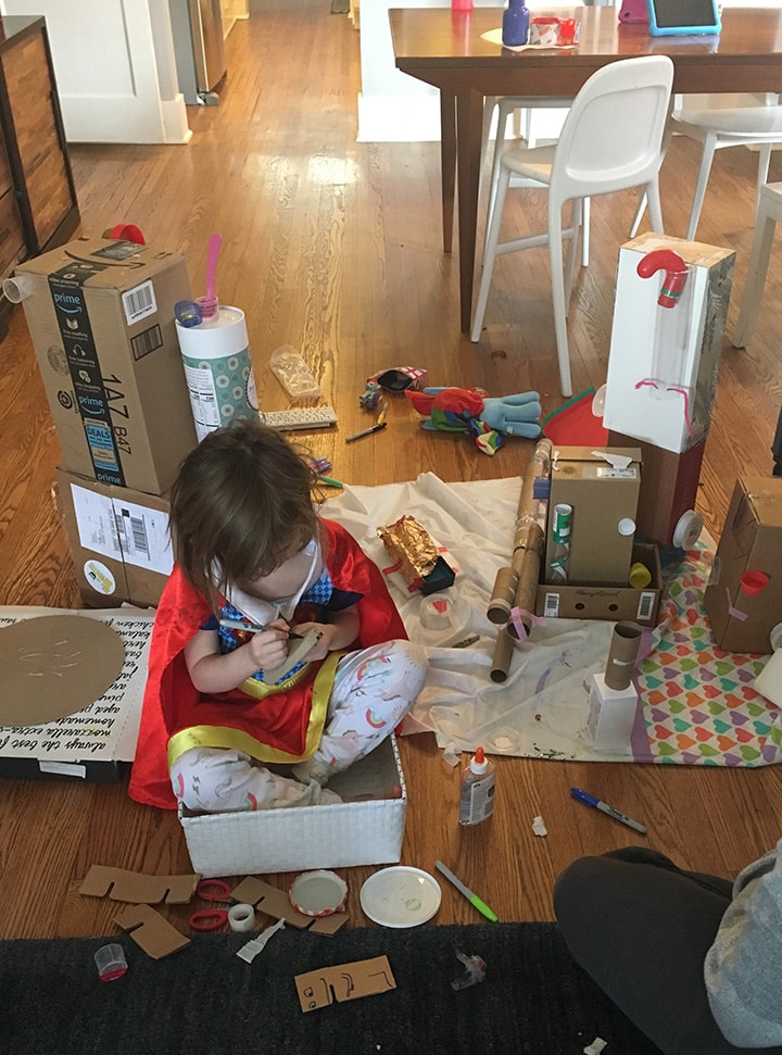 girl upcycling boxes into a robot as a fun at home activity.