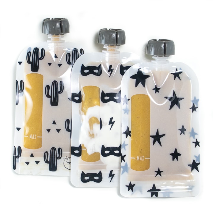 Reusable baby food pouches with banana and peach puree inside.