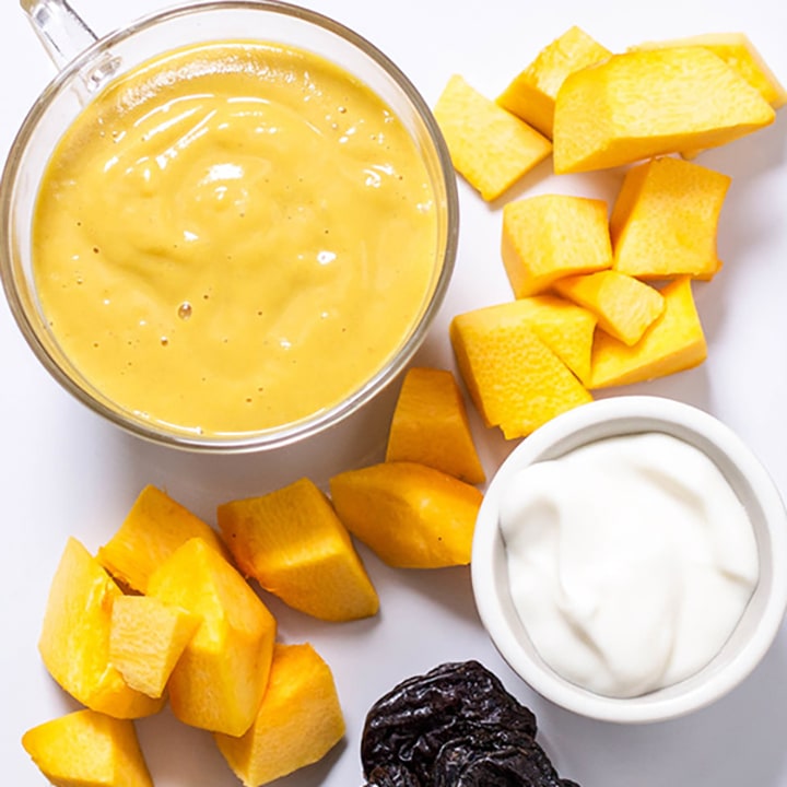 A spread of produce and a small bowl filled with baby food puree.