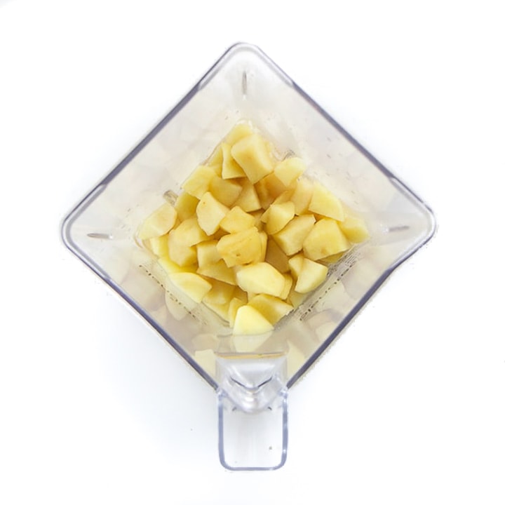 Blender full of chopped and cooked apples.