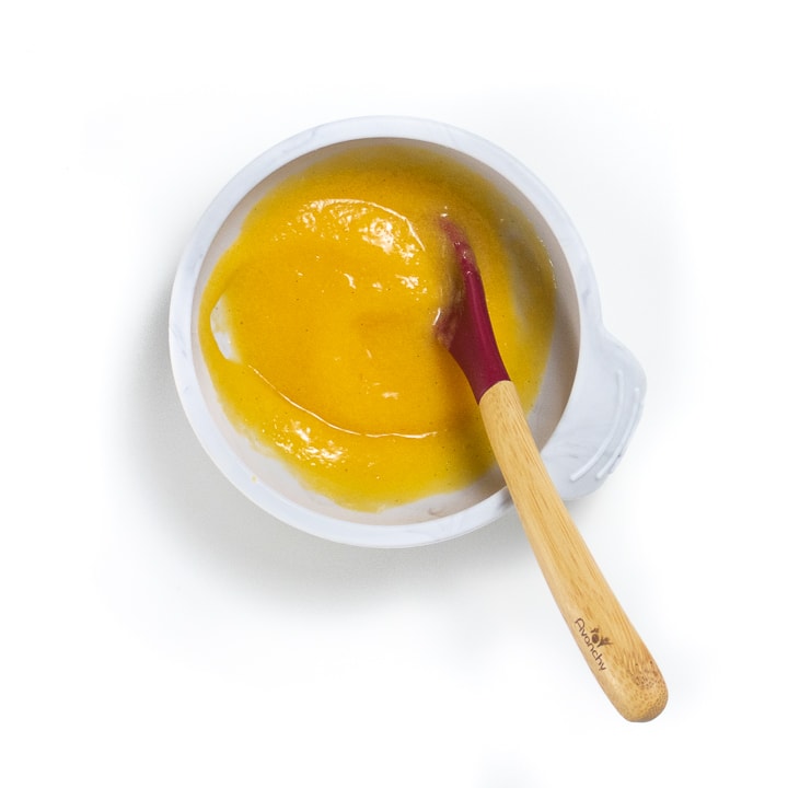 Small gray bowl filled with a peach puree for baby.