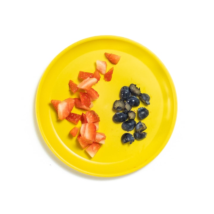 Yellow Plate with chopped fruit for baby.